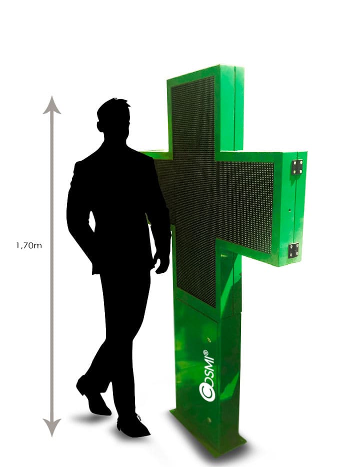 Une croix de pharmacie LED COSMI Full Color XXl en comparaison à un humain de taille 1.70m.